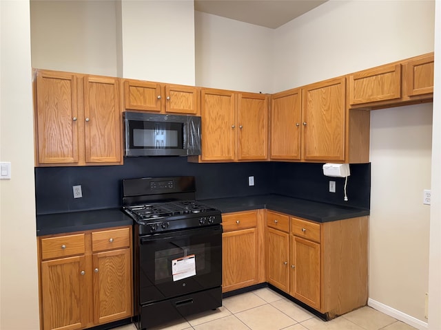 kitchen featuring black range with gas stovetop, tasteful backsplash, and light tile patterned flooring