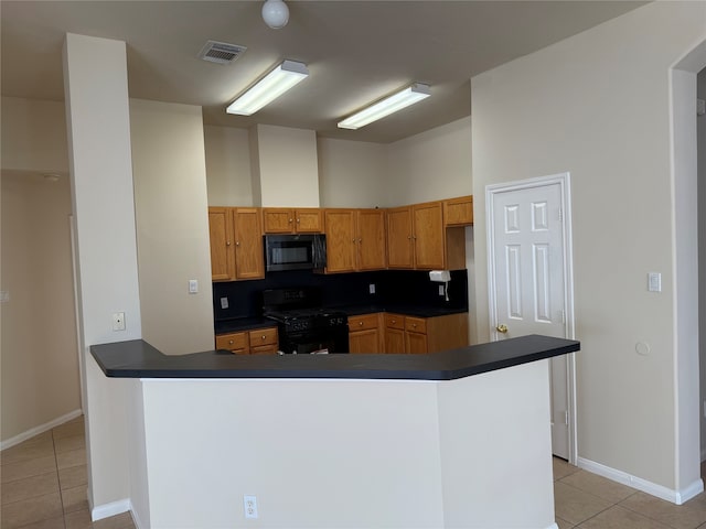 kitchen featuring kitchen peninsula, backsplash, light tile patterned flooring, and black appliances