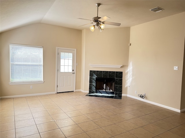 unfurnished living room featuring a tile fireplace, light tile patterned floors, ceiling fan, and lofted ceiling