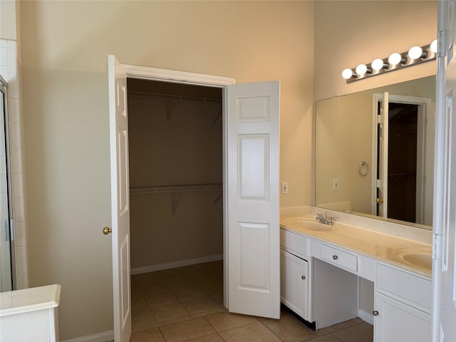 bathroom with tile patterned flooring, vanity, and a shower with door