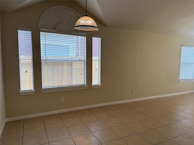 empty room featuring light tile patterned flooring and vaulted ceiling