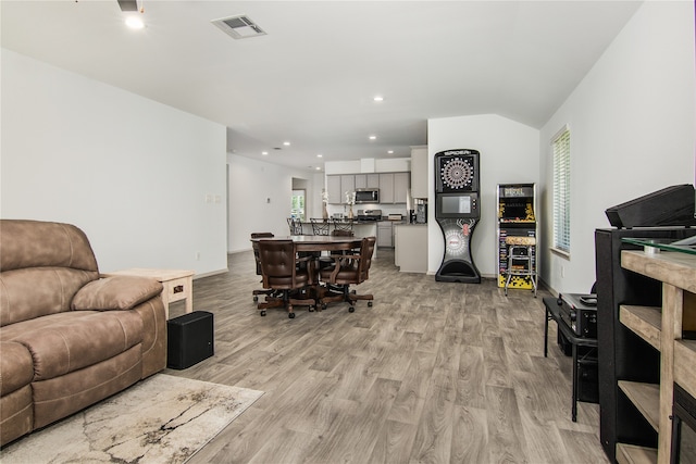 living room featuring light hardwood / wood-style flooring and lofted ceiling