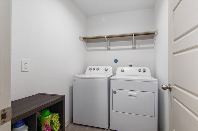 laundry room featuring washer and dryer and light hardwood / wood-style floors