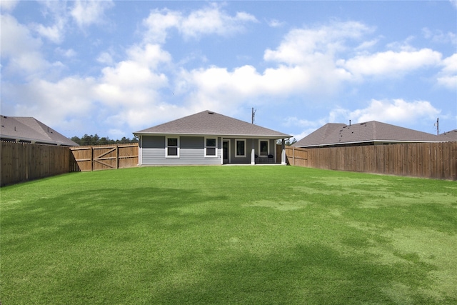 rear view of house featuring a yard