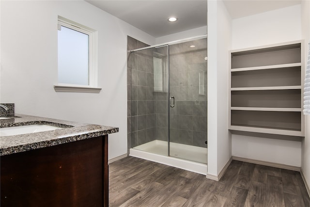 bathroom featuring a shower with door, vanity, and wood-type flooring