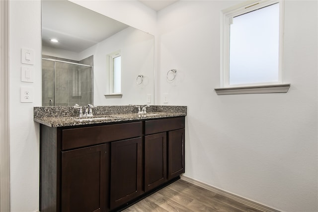 bathroom with hardwood / wood-style flooring, vanity, and an enclosed shower