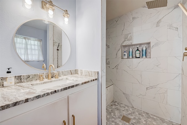 bathroom with vanity and a tile shower