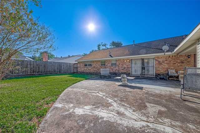 back of house with a yard and a patio