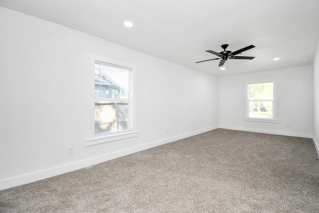 empty room featuring carpet, ceiling fan, and a wealth of natural light