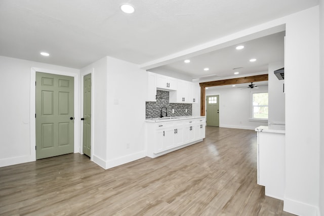 kitchen featuring ceiling fan, light hardwood / wood-style flooring, white cabinets, and sink