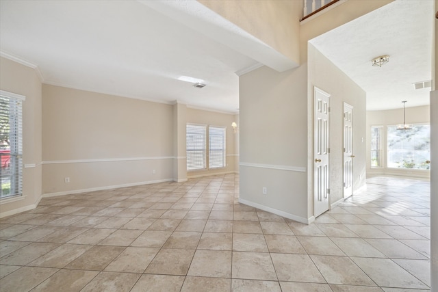 tiled spare room featuring a healthy amount of sunlight and crown molding