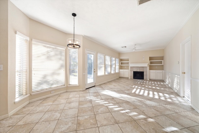 unfurnished living room featuring ceiling fan with notable chandelier, a tile fireplace, ornamental molding, and light tile patterned floors