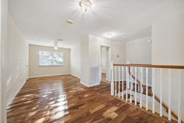 spare room featuring a textured ceiling, dark hardwood / wood-style floors, and ceiling fan