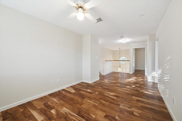 empty room with ceiling fan and dark wood-type flooring