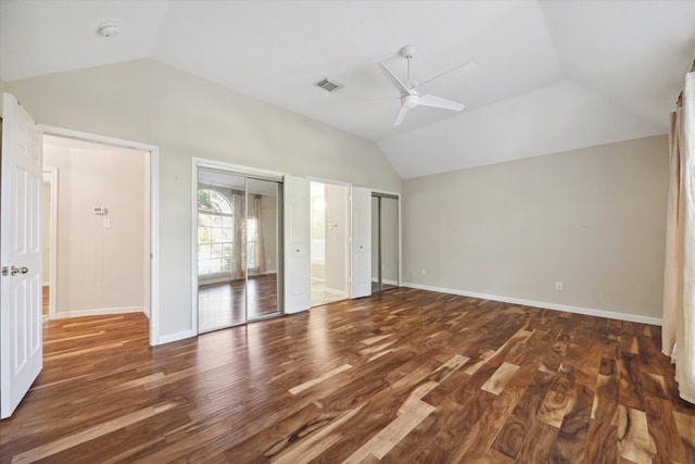 unfurnished bedroom with ceiling fan, dark wood-type flooring, and lofted ceiling