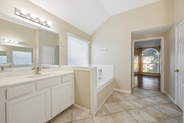 bathroom with a tub to relax in, vanity, wood-type flooring, and vaulted ceiling