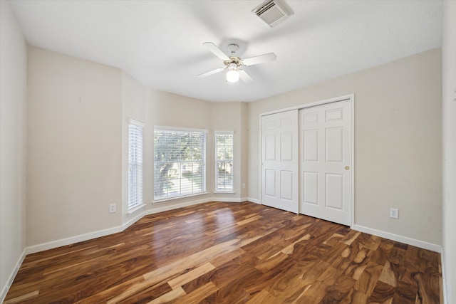 unfurnished bedroom featuring a closet, ceiling fan, and dark wood-type flooring