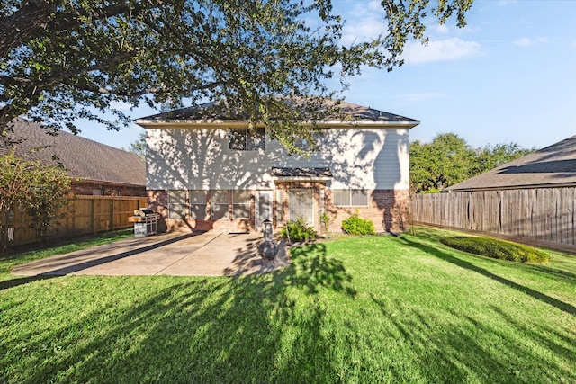 rear view of house featuring a patio area and a yard