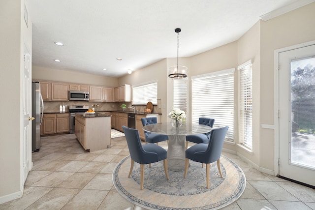 tiled dining area featuring a chandelier, a wealth of natural light, and sink