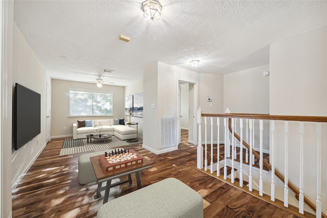 interior space featuring a textured ceiling, dark hardwood / wood-style flooring, and ceiling fan