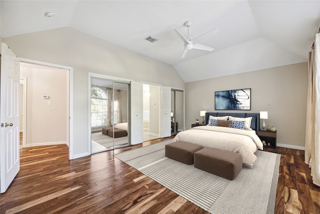 bedroom featuring two closets, ceiling fan, dark hardwood / wood-style flooring, and vaulted ceiling