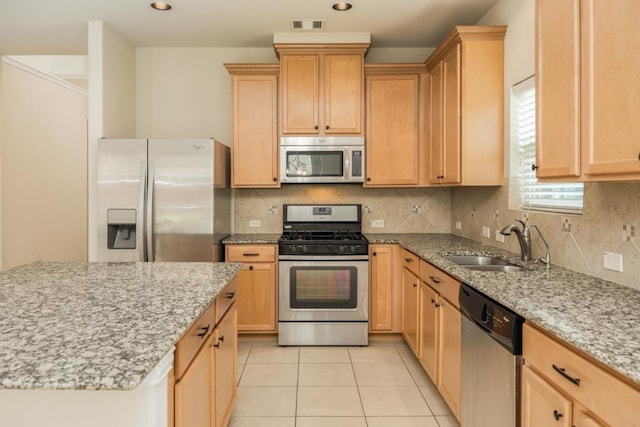 3008 Brandy Branch Ct, League City, TX 77573 - kitchen featuring light tile patterned flooring, light stone counters, a sink, stainless steel appliances, and visible vents