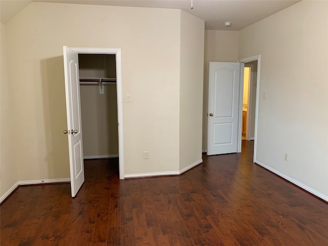 unfurnished bedroom with dark hardwood / wood-style flooring and a closet