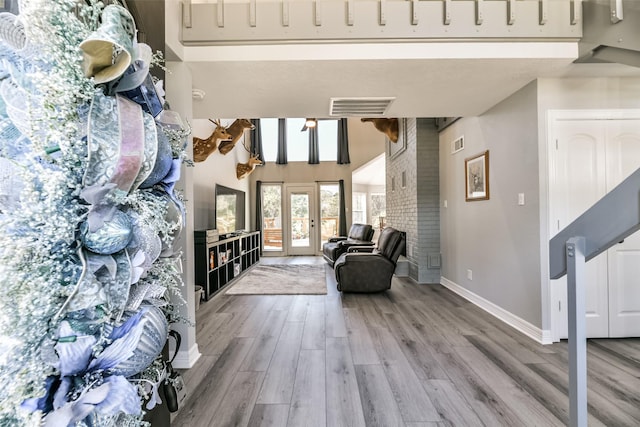 interior space featuring hardwood / wood-style flooring, a towering ceiling, and french doors