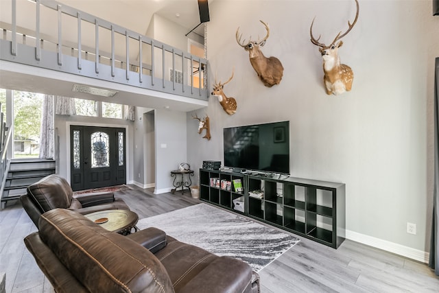 living room featuring a towering ceiling and hardwood / wood-style flooring