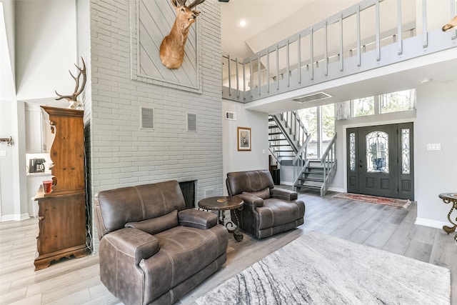 living room featuring a towering ceiling and light wood-type flooring