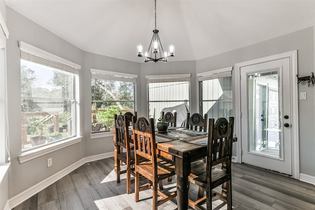 dining area with dark hardwood / wood-style flooring and a notable chandelier