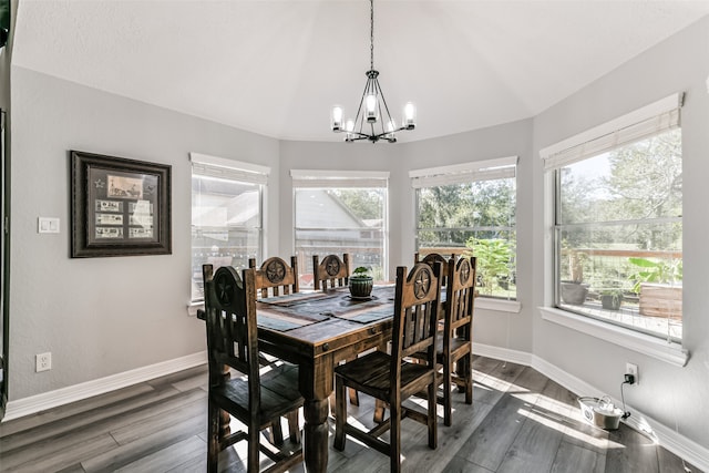 dining space with dark hardwood / wood-style floors and an inviting chandelier