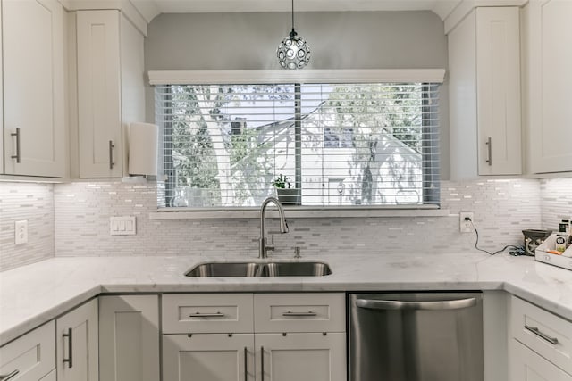 kitchen featuring decorative backsplash, light stone counters, stainless steel dishwasher, sink, and hanging light fixtures