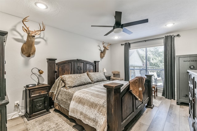 bedroom with ceiling fan, light wood-type flooring, and a textured ceiling