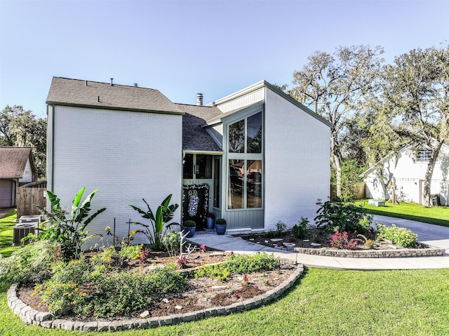 exterior space with central AC unit and a front yard