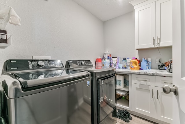 washroom with separate washer and dryer and cabinets