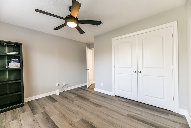 unfurnished bedroom with ceiling fan, light hardwood / wood-style floors, and a closet