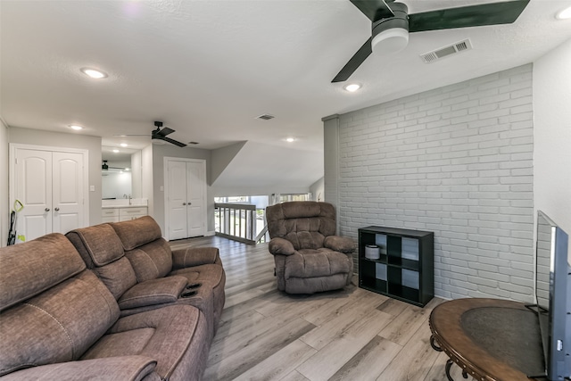 living room with light wood-type flooring, ceiling fan, and sink