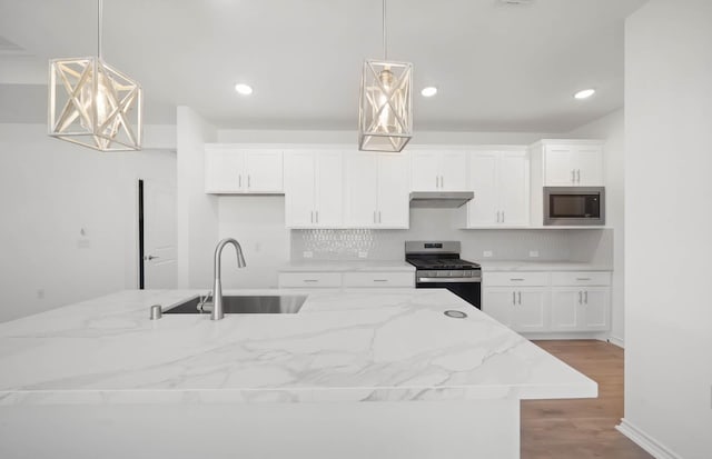 kitchen with built in microwave, pendant lighting, sink, and stainless steel range with gas stovetop