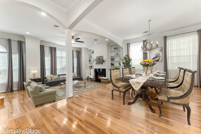 dining space featuring ceiling fan with notable chandelier, light wood-type flooring, and a wealth of natural light