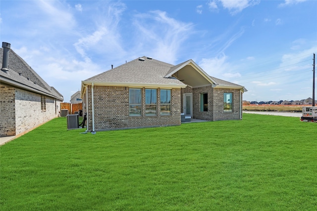 back of property featuring a yard and central AC