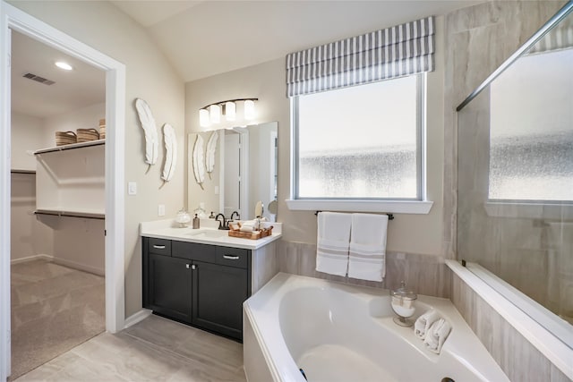 bathroom featuring tile patterned floors, vanity, vaulted ceiling, and independent shower and bath