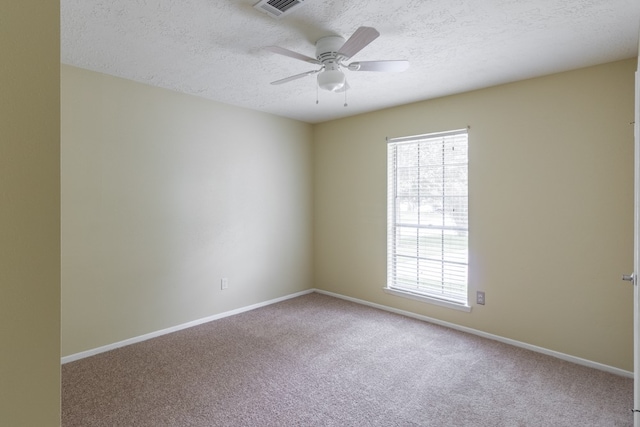 spare room featuring ceiling fan, carpet floors, and a textured ceiling