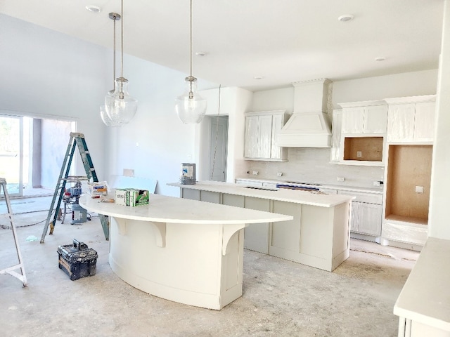 kitchen featuring custom exhaust hood, a center island, white cabinetry, and hanging light fixtures