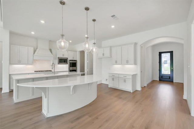 9923 Hunters Run Dr, Missouri City, TX 77459 - kitchen featuring appliances with stainless steel finishes, a large island with sink, tasteful backsplash, custom exhaust hood, and recessed lighting