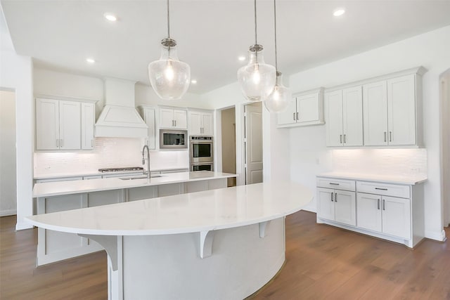 9923 Hunters Run Dr, Missouri City, TX 77459 - kitchen with appliances with stainless steel finishes, an island with sink, tasteful backsplash, premium range hood, and recessed lighting