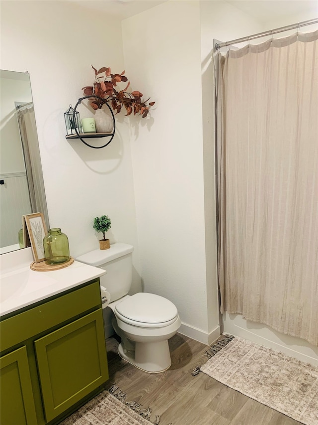 full bathroom with shower / bath combination with curtain, vanity, hardwood / wood-style flooring, and toilet