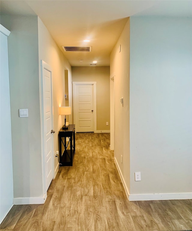 corridor with light hardwood / wood-style floors