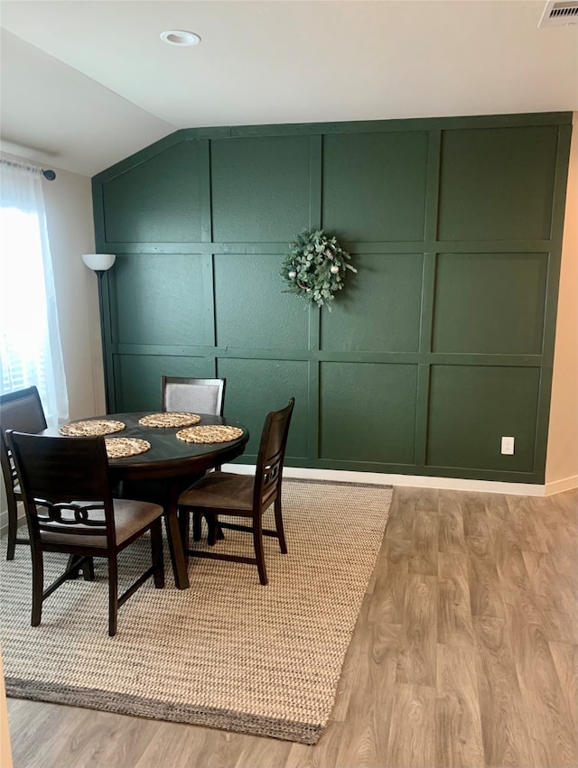 dining area with vaulted ceiling and light hardwood / wood-style flooring