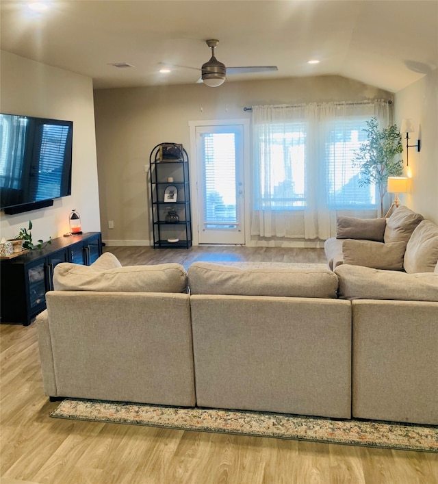 living room with hardwood / wood-style flooring, vaulted ceiling, and ceiling fan